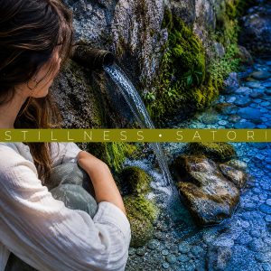 Stillness Satori Woman sitting next to a rushing stream in the Pyrenees Mountains